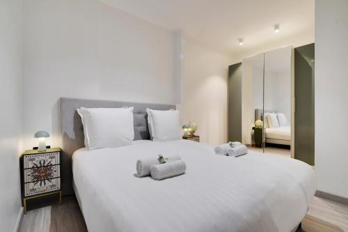 une chambre avec un grand lit blanc avec deux serviettes dessus dans l'établissement Le chic à Paris 4P BERCY - DAUMESNIL, à Paris