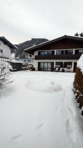 pokryty śniegiem dziedziniec przed budynkiem w obiekcie Apartment-Alpenfantasie w mieście Zell am See