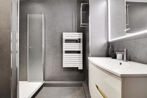 une salle de bain avec un lavabo et une douche dans l'établissement Elegance a paris 4P BERCY - DAUMESNIL, à Paris