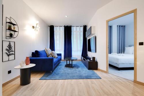 - un salon avec un canapé bleu et un lit dans l'établissement Elegance a paris 4P BERCY - DAUMESNIL, à Paris