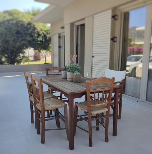 a wooden table and chairs on a porch at Nerinalia Residence in Áyioi Apóstoloi