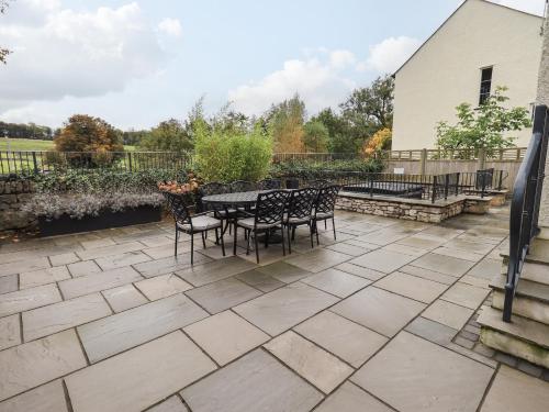 a patio with a table and chairs on it at Pen-y-Ghent in Carnforth
