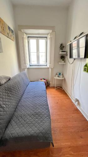 a bedroom with a bed and a window and a television at Sweet Alfama, Apartment 2 in Lisbon