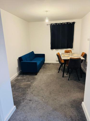 a living room with a blue couch and a table at Canvey Stay Entire Flat in Canvey Island