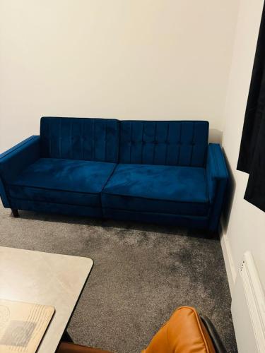 a blue couch sitting in a living room at Canvey Stay Entire Flat in Canvey Island