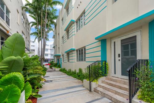 a sidewalk next to a building with palm trees at Luxuri Suites in Miami Beach