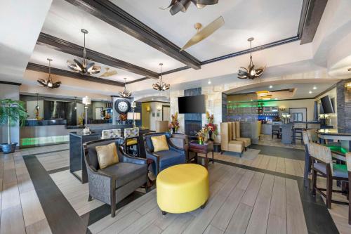 a lobby of a hotel with chairs and a bar at Best Western Plus Emerald Inn & Suites in Garden City