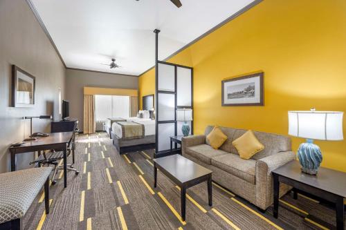 a living room with a couch and a bed at Best Western Plus Emerald Inn & Suites in Garden City