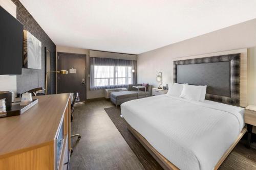 a hotel room with a large bed and a living room at Aiden by Best Western South Reno in Reno