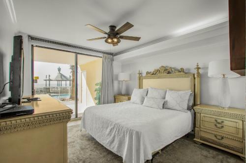 a bedroom with a bed with a ceiling fan and a television at Summer House 103A by Vacation Homes Collection in Orange Beach