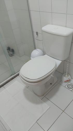 a white bathroom with a toilet and a shower at Executive Celita Franco in Feira de Santana