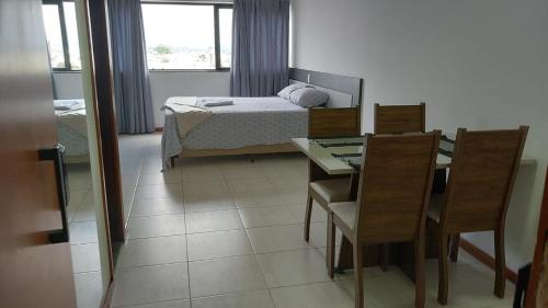 a bedroom with a bed and a table and chairs at Executive Celita Franco in Feira de Santana