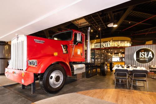 a red truck parked in a room with tables and chairs at Hard Rock Hotel Riviera Maya - All Inclusive in Puerto Aventuras