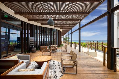 a building with a deck with chairs and a table at Hard Rock Hotel Riviera Maya - All Inclusive in Puerto Aventuras