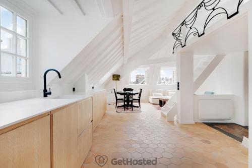une cuisine blanche avec un évier et une table dans l'établissement Ile de la Cite - Seine & Notre Dame View, à Paris