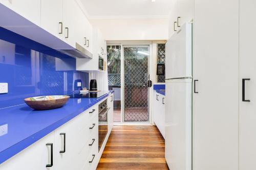 a kitchen with white cabinets and blue countertops at Tondio Terrace Flat 3 - Pet Friendly in Gold Coast