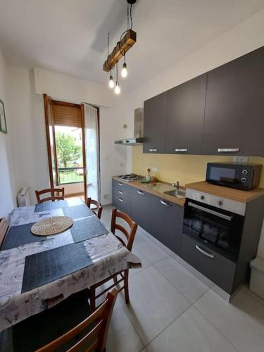 a kitchen with a table and a dining room at Appartamento Puccini - Zona Firenze in Le Sieci