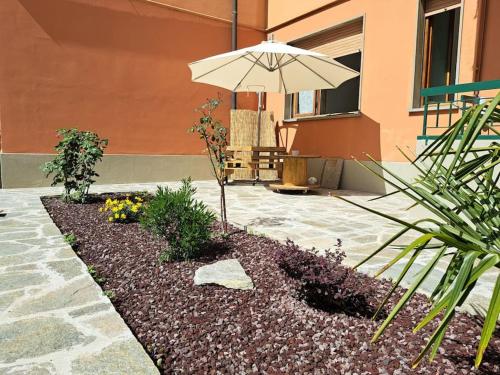 a patio with an umbrella and some flowers at Appartamento Puccini - Zona Firenze in Le Sieci