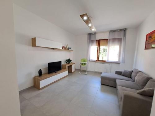 a living room with a couch and a tv at Appartamento Puccini - Zona Firenze in Le Sieci