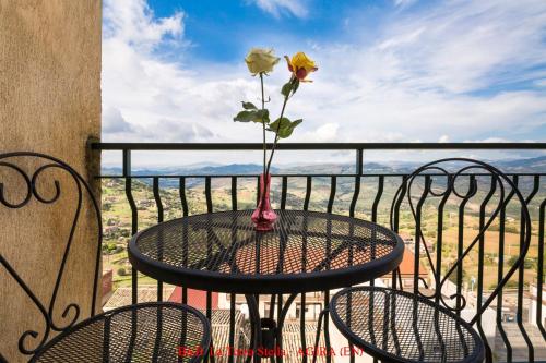 a vase with a flower sitting on a table on a balcony at Casa Albergo La Terza Stella in Agira