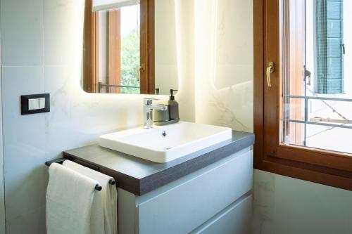un bagno con un lavandino bianco e uno specchio di Treviso City Center BnB - Comodo per Stazione e Centro Città a Treviso