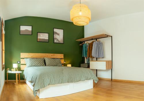 una camera da letto verde con un letto e una parete verde di Treviso City Center BnB - Comodo per Stazione e Centro Città a Treviso