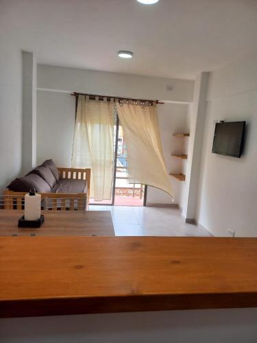 a living room with a couch and a television at Depto 41 in Santa Teresita