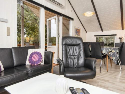 a living room with black leather chairs and a table at Scenic Fjord Retreat-By Traum in Vemb