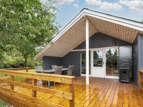 a large deck with a grill and a house at Scenic Fjord Retreat-By Traum in Vemb