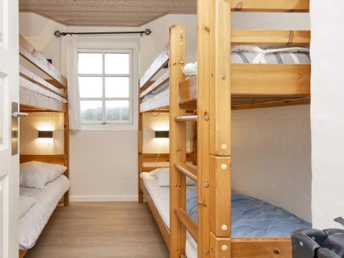 a bunk bed room with three bunk beds and a window at 4 star holiday home in Ulfborg in Ulfborg