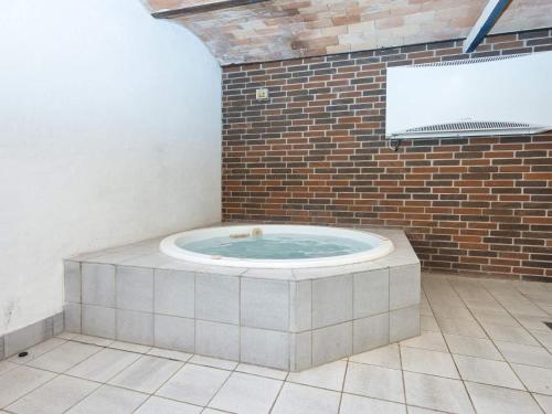 a hot tub in a room with a brick wall at Luxury Pool House Retreat - By Traum Ferienwohnungen in Skjern