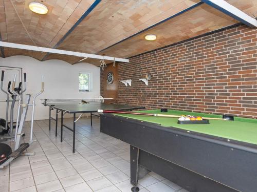 a room with two pool tables and a brick wall at Luxury Pool House Retreat - By Traum Ferienwohnungen in Skjern
