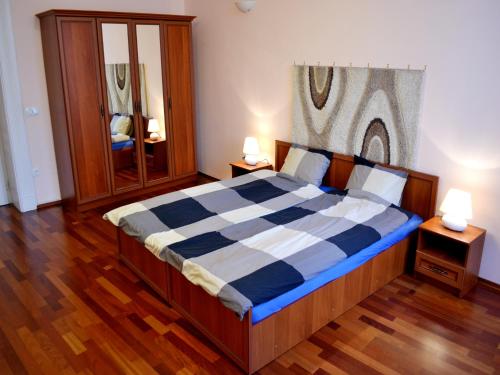 ブダペストにあるガブリエル アパートメントのベッドルーム1室(大型ベッド1台、青と白のチェック入り毛布付)
