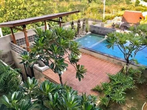 a swimming pool in the middle of a garden at The balangan studio room 3mins to balangan beach in Uluwatu