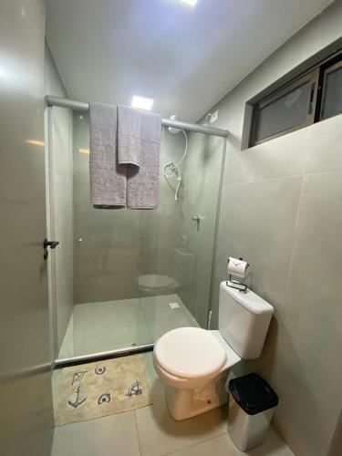 een badkamer met toilet en glazen douche bij sol flat cabo branco 50 metros do mar in João Pessoa