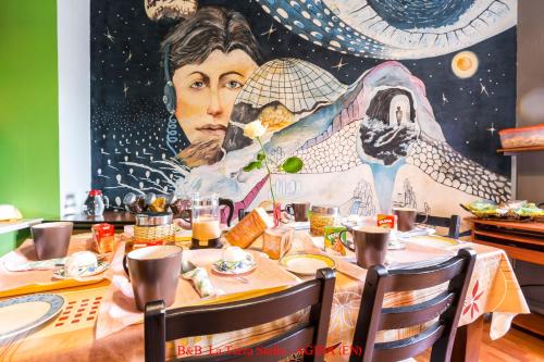 a dining room table with a large painting on the wall at Casa Albergo La Terza Stella in Agira