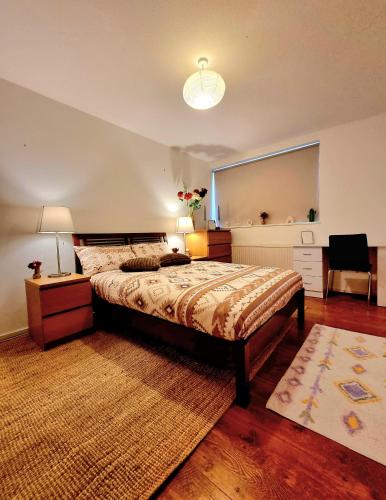 a bedroom with a large bed and a table and a chair at Charming Central london 4 bedroom duplex with private entrance in London