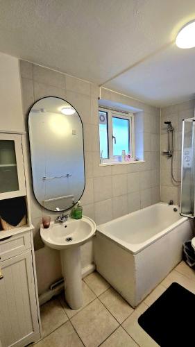 a bathroom with a sink and a bath tub and a mirror at Charming Central london 4 bedroom duplex with private entrance in London
