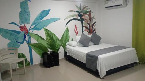 a bedroom with a bed with plants on the wall at Hosteria Cattleya in San Andrés