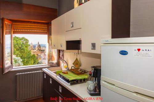 a kitchen with a white refrigerator and a window at Casa Albergo La Terza Stella in Agira
