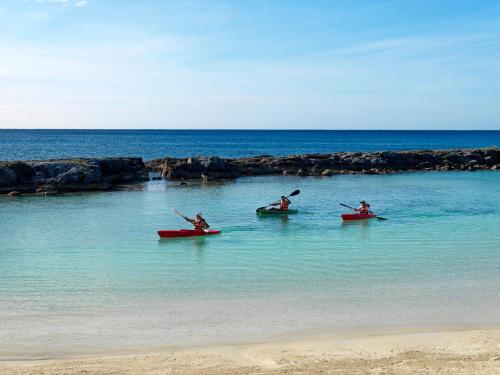 three people in kayaks in the water on the beach at Hard Rock Hotel Riviera Maya - Heaven Adults Only - All Inclusive in Puerto Aventuras