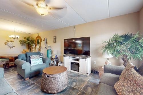 a living room with a couch and chairs and a fireplace at Beachview Condominiums #111 in South Padre Island