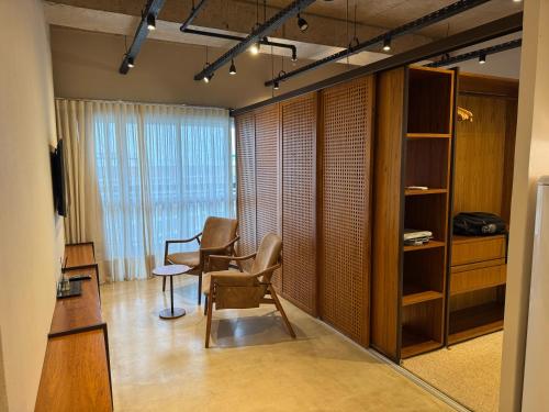 une chambre avec deux chaises, une table et une fenêtre dans l'établissement Vision - confortável, prático e aconchegante, à Brasilia