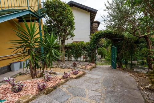 a garden in front of a house with a fence at La casa sul torrente - Lake View in Cernobbio