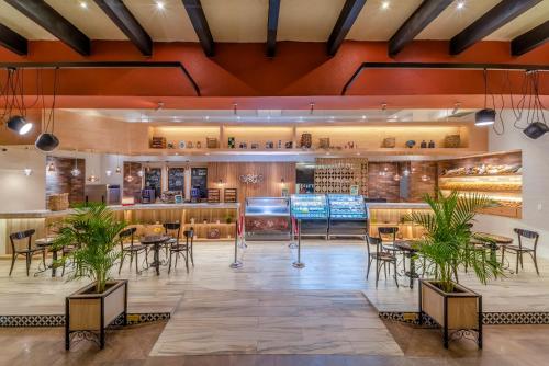 a lobby of a restaurant with tables and chairs at Hard Rock Hotel Riviera Maya - Heaven Adults Only - All Inclusive in Puerto Aventuras