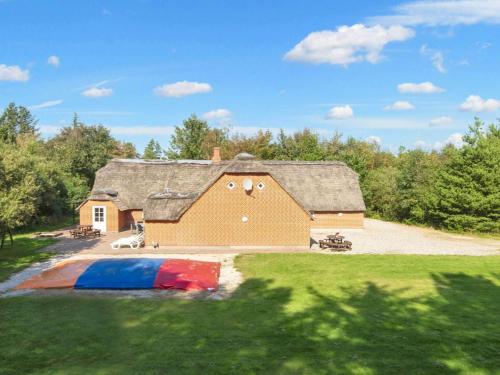 a large house with a thatched roof and a yard at Luxury Thatched Retreat - By Traum Ferienwohnungen in Ulfborg