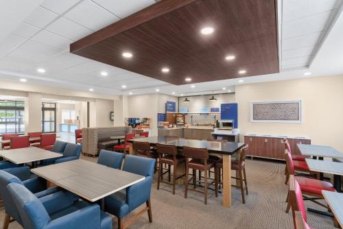 a dining room with tables and chairs in a library at Holiday Inn Express Hotel & Suites Coralville by IHG in Coralville