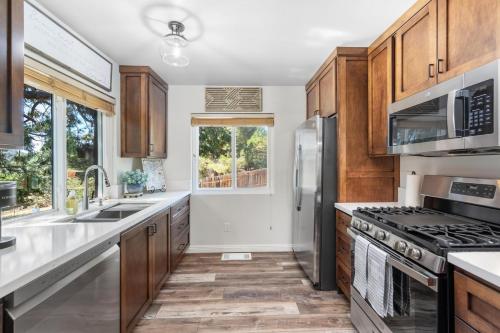 a kitchen with stainless steel appliances and wooden cabinets at Julian Cafe Cottages With Breakfast At The Julian Cafe in Julian