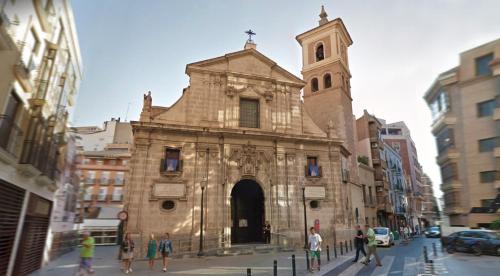 an old church with a clock tower on a city street at Casa San Pedro 1 in Murcia