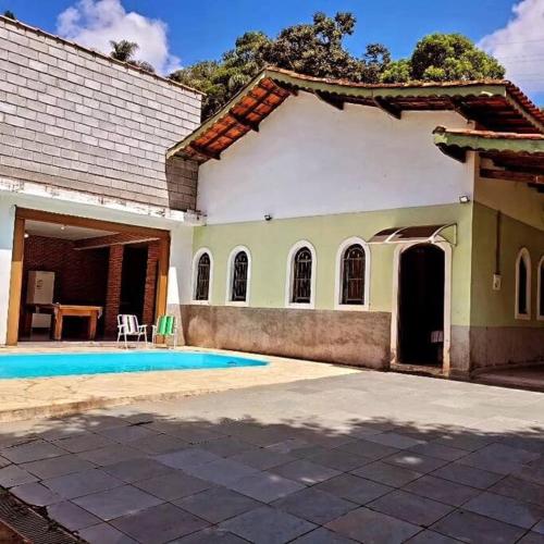 a house with a swimming pool in front of it at Chácara dos Sonhos em Mairiporã in Mairiporã